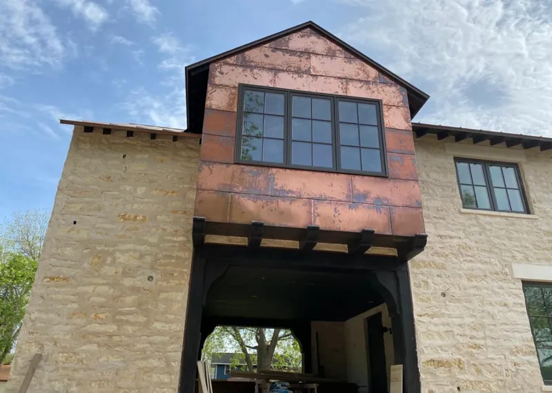 Copper metal panel facade on a stone building for Roof Repair in Marlin